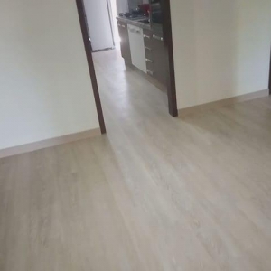 Piso LVT instalado com rodapé de madeira